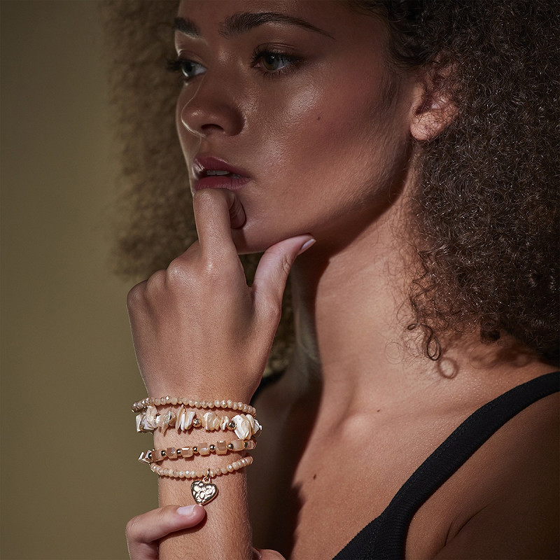 The Moshi Perlenarmband Alva mit Glasperlen in Beige und Herz Anhänger, elastisches Boho Armband Set am Handgelenk getragen